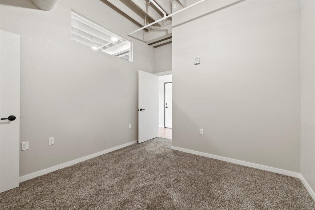 a room with a carpeted floor and white walls in a affordable Brooke Street Loft