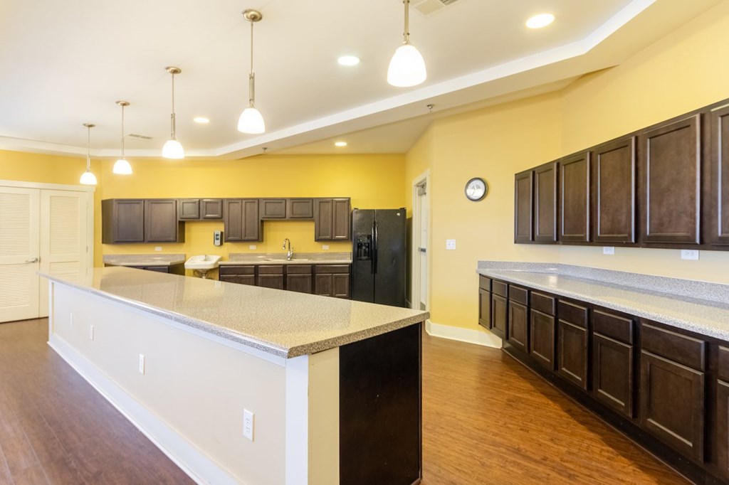 A kitchen with a white counter top and brown cabinets.