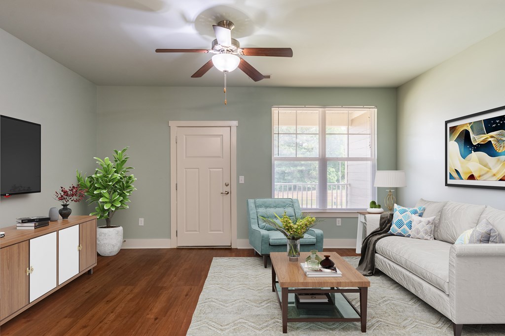 A living room with a couch, chair, and potted plant.