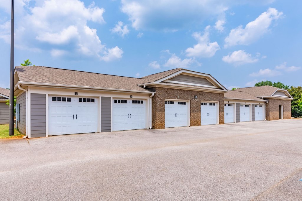 A building with a brown roof and white garage doors.