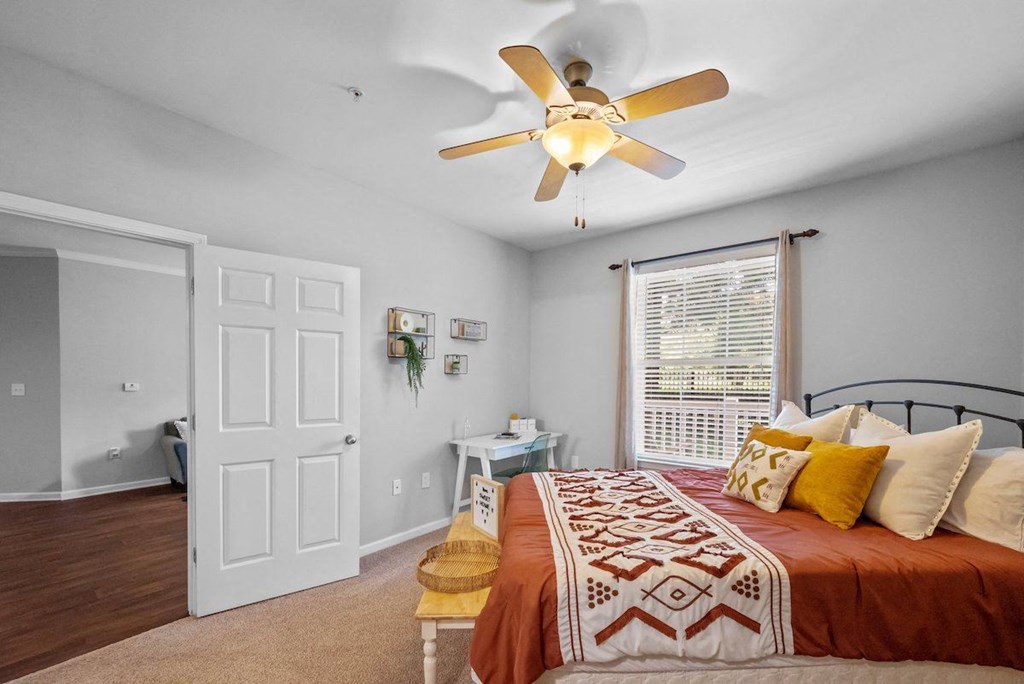 a bedroom with a bed and a ceiling fan