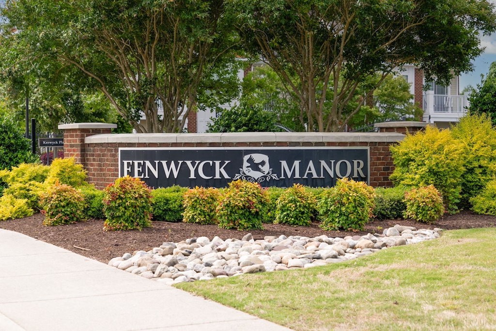 brick monement sign with Fenwyck Manor name and logo in front of community entrance