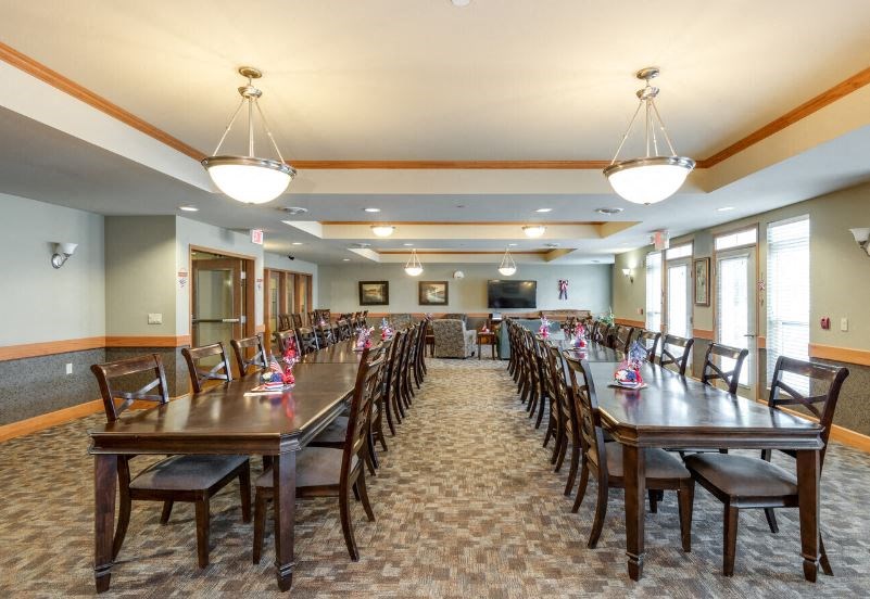 large community room with tables and chairs at Harborside Commons Apartments