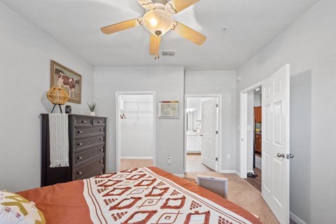 a spacious bedroom with a bed and a ceiling fan