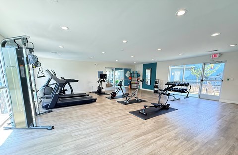 A gym with treadmills, elliptical machines, and other exercise equipment. at Huntsville Landing Apartments, Alabama, 35806
