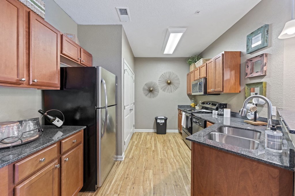 Fenwyck Manor Apartment home kitchen with wood cabinets, granite countertops, and stainless steel appliances