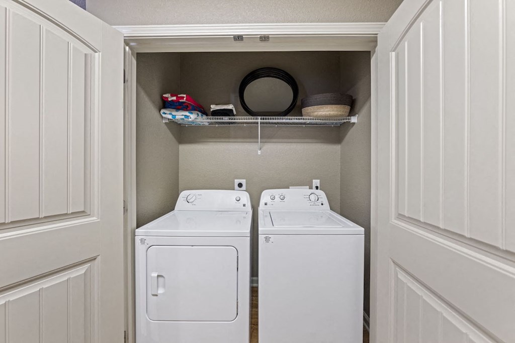 in-home laundry room with built-in shelving and a washer and dryer