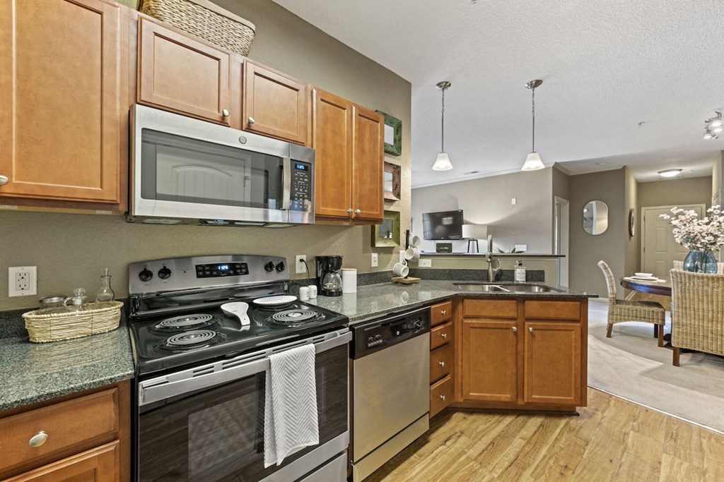 kitchen with stainless steel appliances, granite countertops, and wood cabinets at Fenwyck Manor