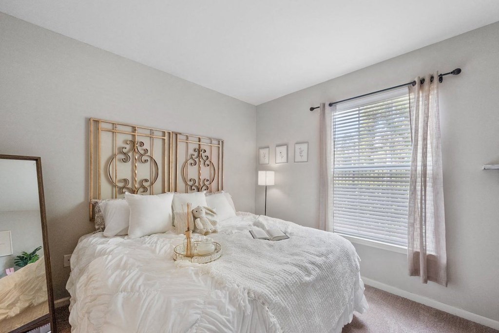 a bedroom with a large bed and a large window in Centerville Manor Model apartment
