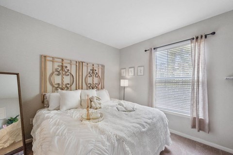 a bedroom with a large bed and a large window in Centerville Manor Model apartment