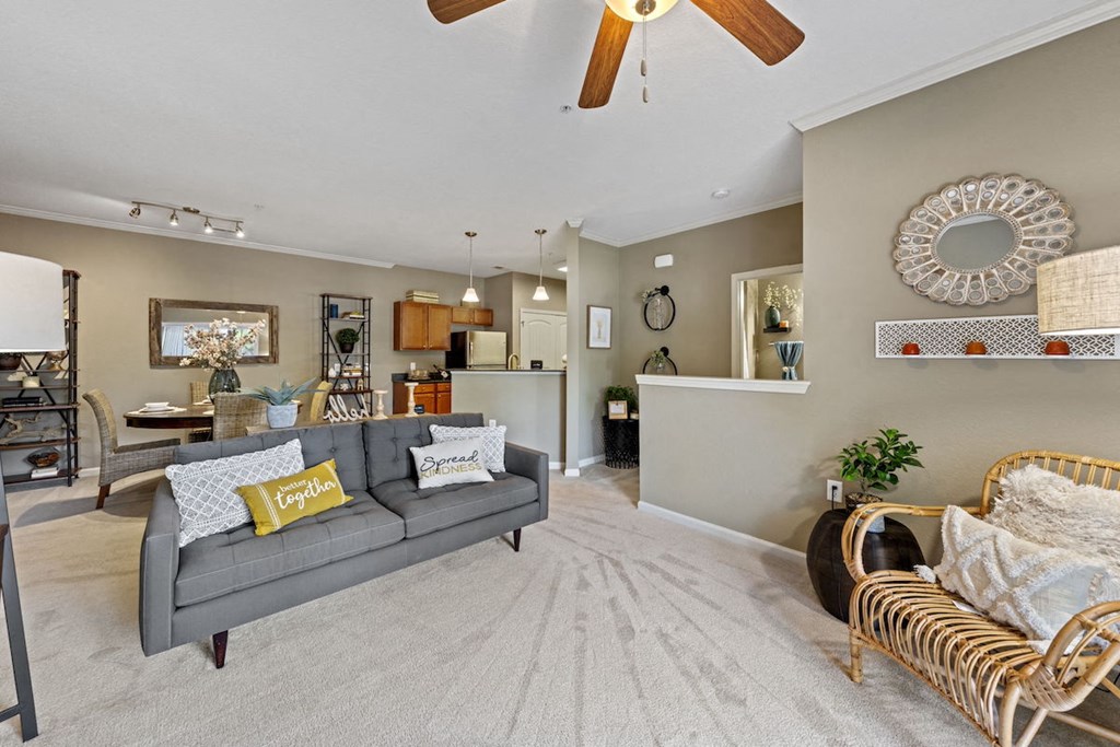 large Fenwyck Manor apartment home living room, dining room, and kitchen with plush carpeting and ceiling fan