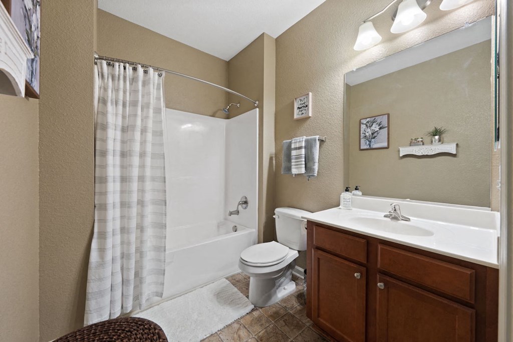 spacious bathroom with tub/shower, and sink vanity with a large mirror and light kit