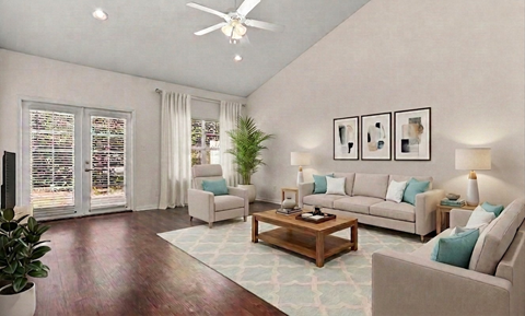 A living room with a couch, chair, and potted plant.