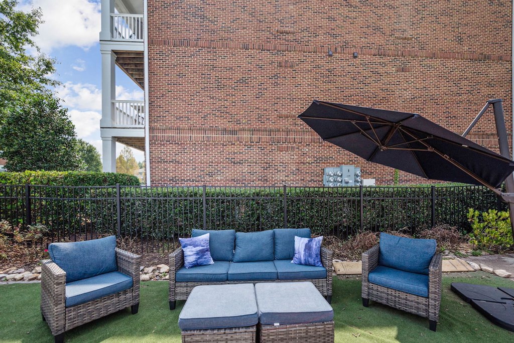 green space with patio lounge set and big umbrella at Centerville Manor Apartments
