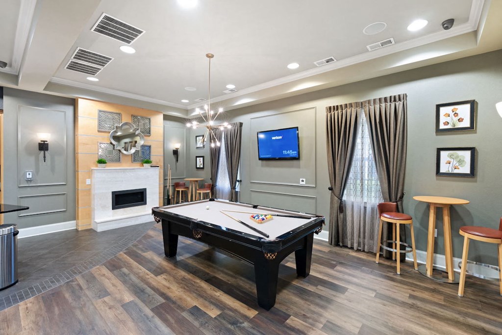 a spacious game room with a pool table and a flat screen tv