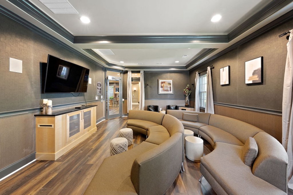 Fenwyck Manor's media room with large TV and half-circle couches