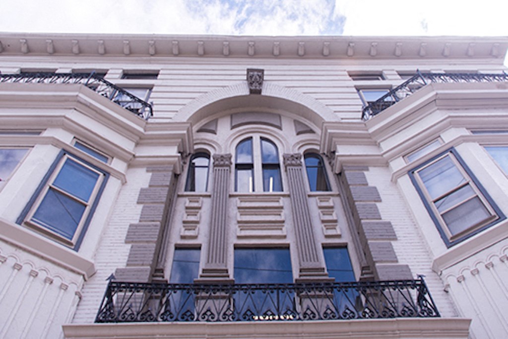 fancy brick and stone apartment building with massive windows and iron balcony at 87 Whitney Pl in Buffalo, NY