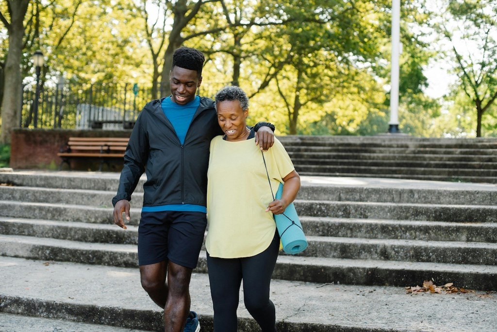 a man and a woman walking down a set of stairs in a park