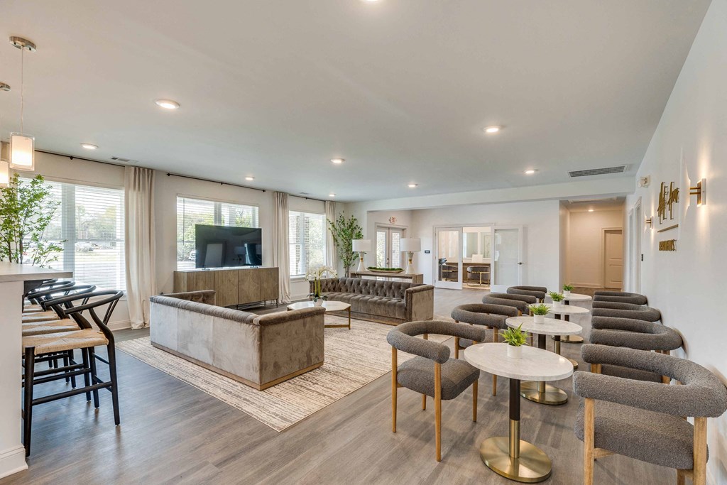 a living room with couches tables and chairs and a television