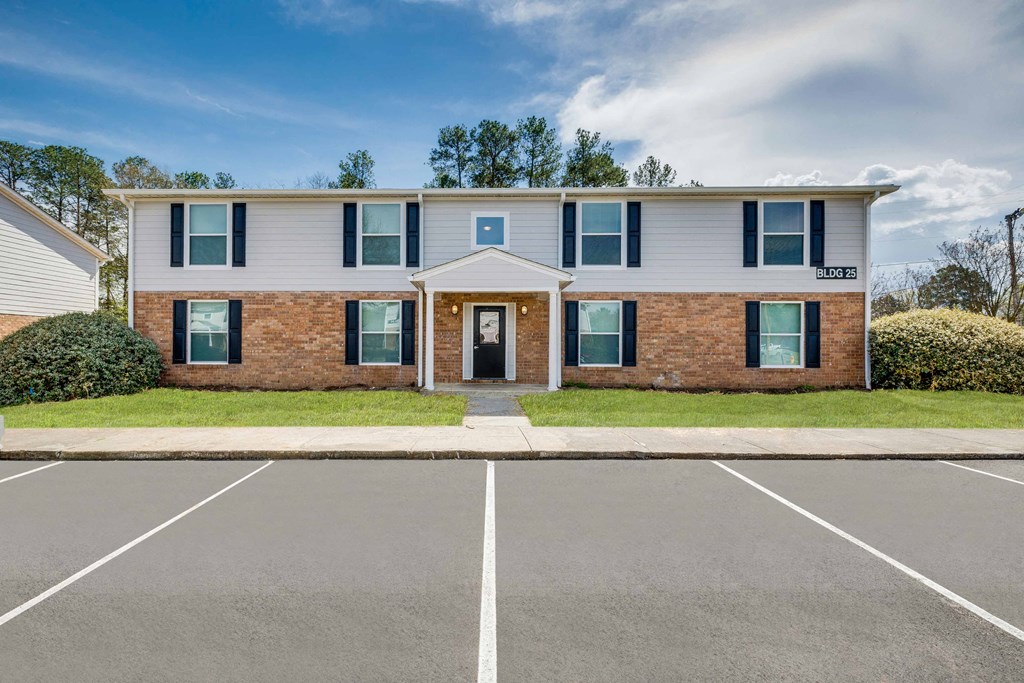 a white building with windows and a door in a parking lot