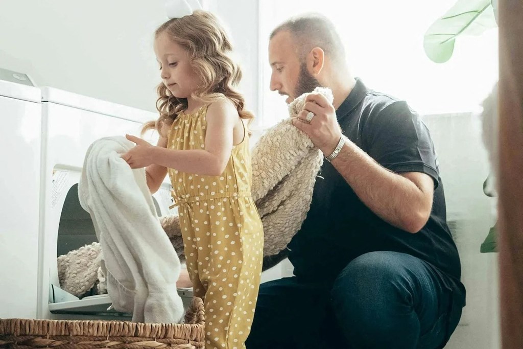 a father and daughter playing with a stuffed animal
