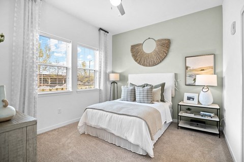 a bedroom with a bed and two windows