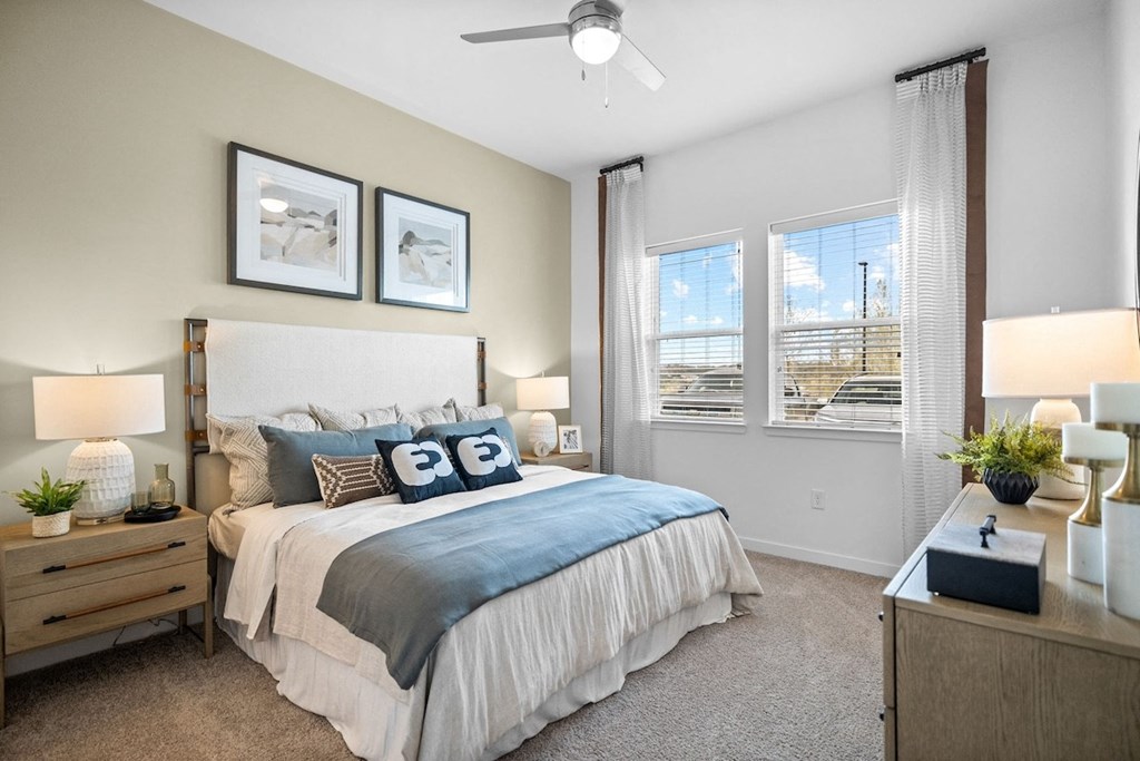 a bedroom with a bed and two windows