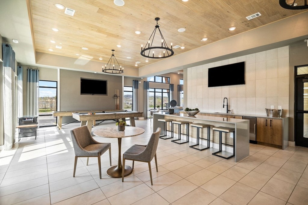 Canopy-Park-Pelham-PG-32 a large lobby with tables and chairs and a kitchen