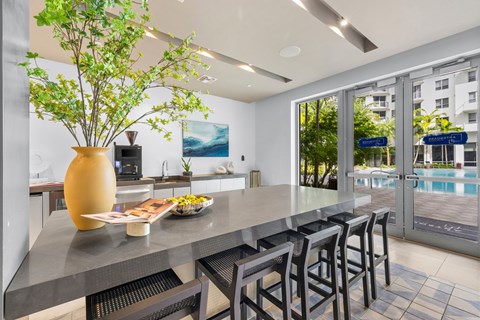 A kitchen with a table and chairs and a vase with a plant in it.