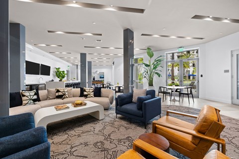 A modern living room with a variety of furniture and plants.