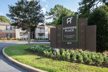 Large monument sign for Ashford Place surrounded by flowers at entrance