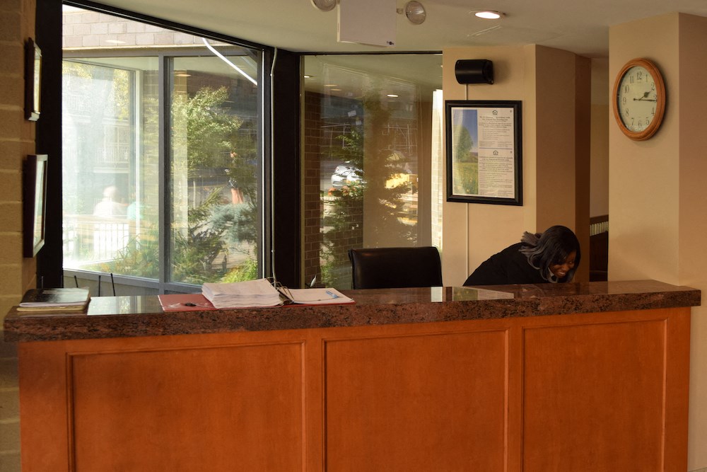 a woman is sitting at the front desk of an office