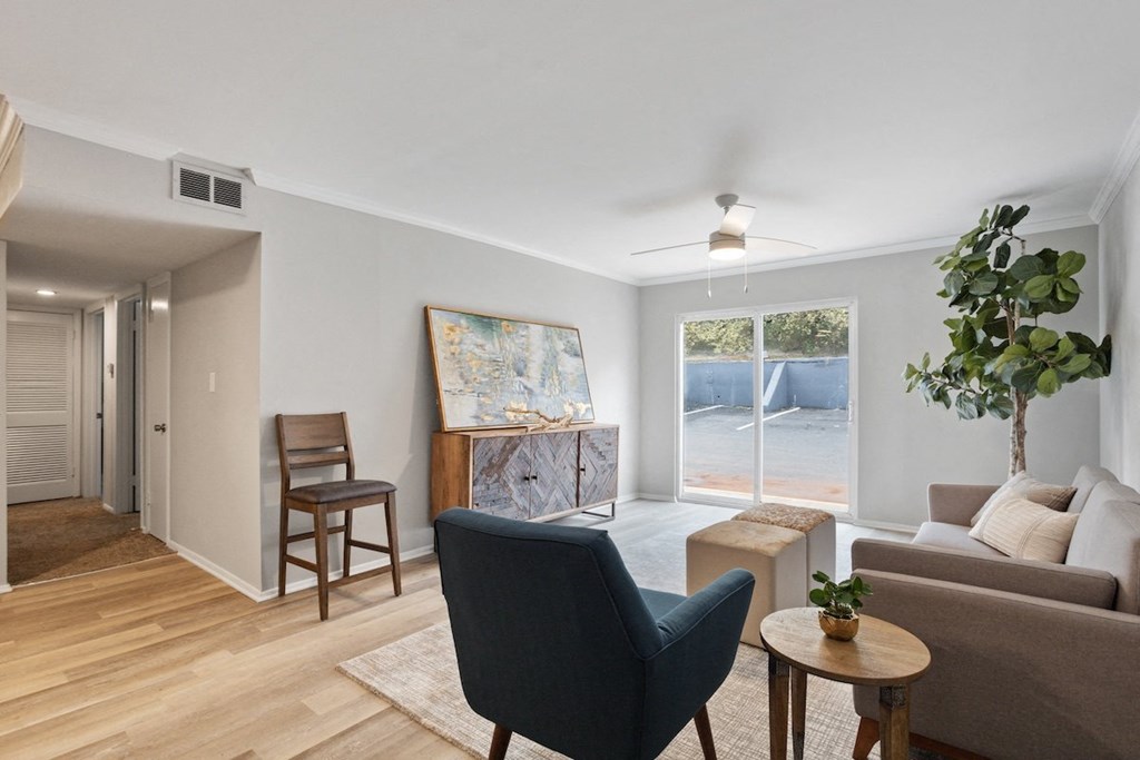 a furnished living room with warm wood floors, large windows, an illuminated ceiling fan at Mountainside Apartments