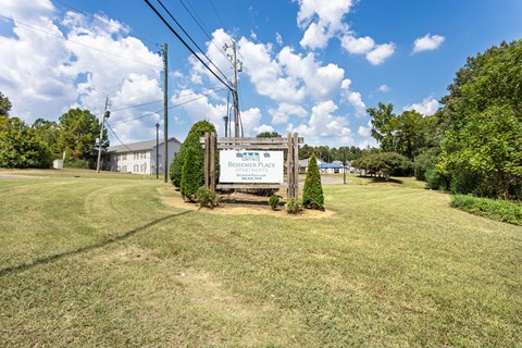 A sign in front of a grassy area that says "Residence Place".