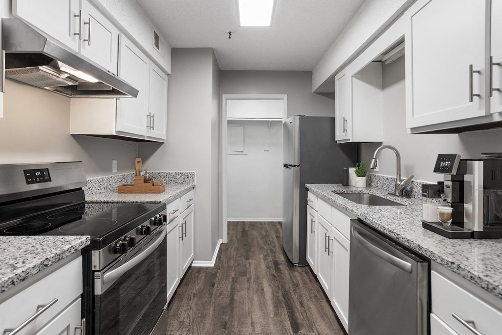 a kitchen with white cabinets and stainless steel appliances and granite counter tops