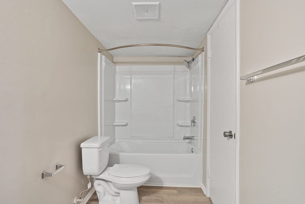 A bathroom with toilet, tub, and shower at Mountainside Apartments
