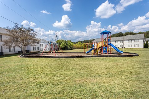 A playground with a blue and yellow swing set.