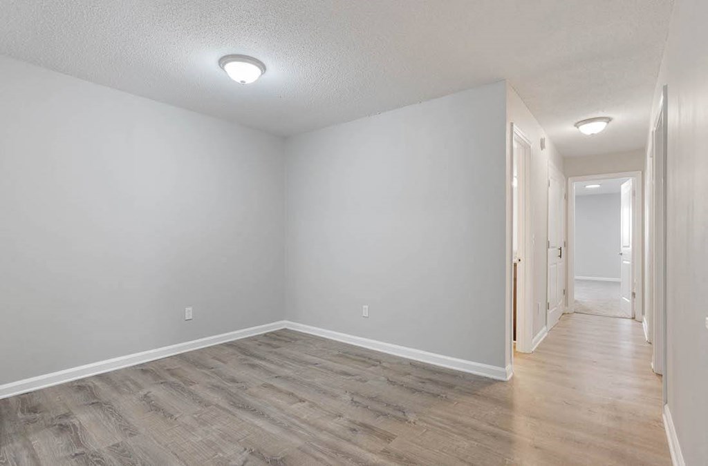a living room/dining room area with overhead lighting and hardwood flooring