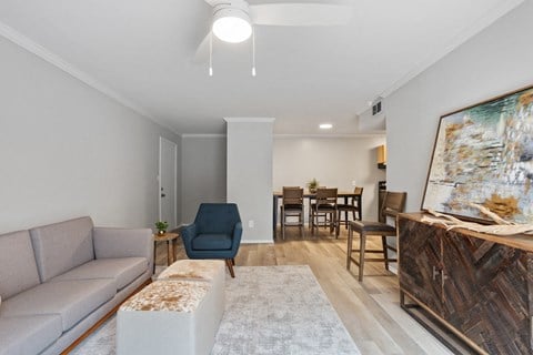 a living room with a couch and a chair and a dining room table