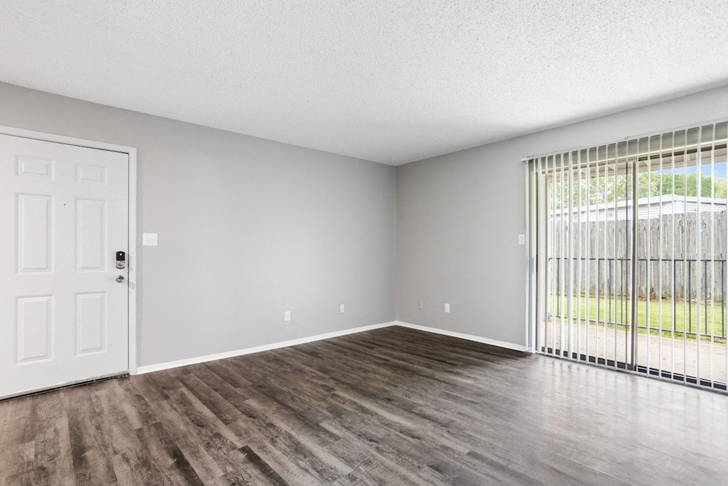 an empty living room with a door to a patio