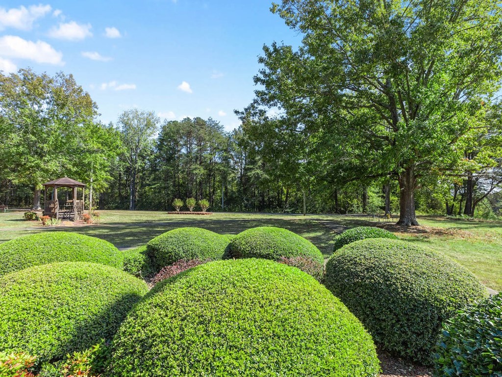 a group of trim hedges and a gazebo in the courtyard at Village Square Apartments for seniors