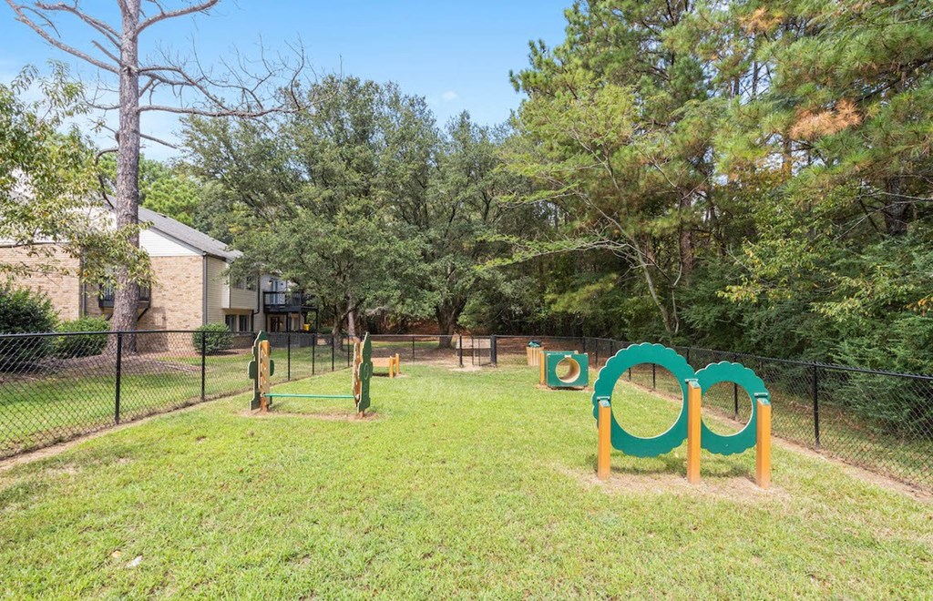 large fenced bark park with agility play equipment at The Onyx Hoover