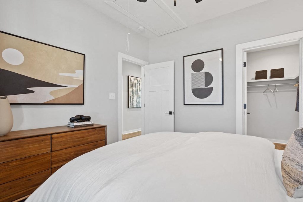 a bedroom with a walk-in closet and model furniture at Sanctuary at Indian Creek rental homes in Madison, AL