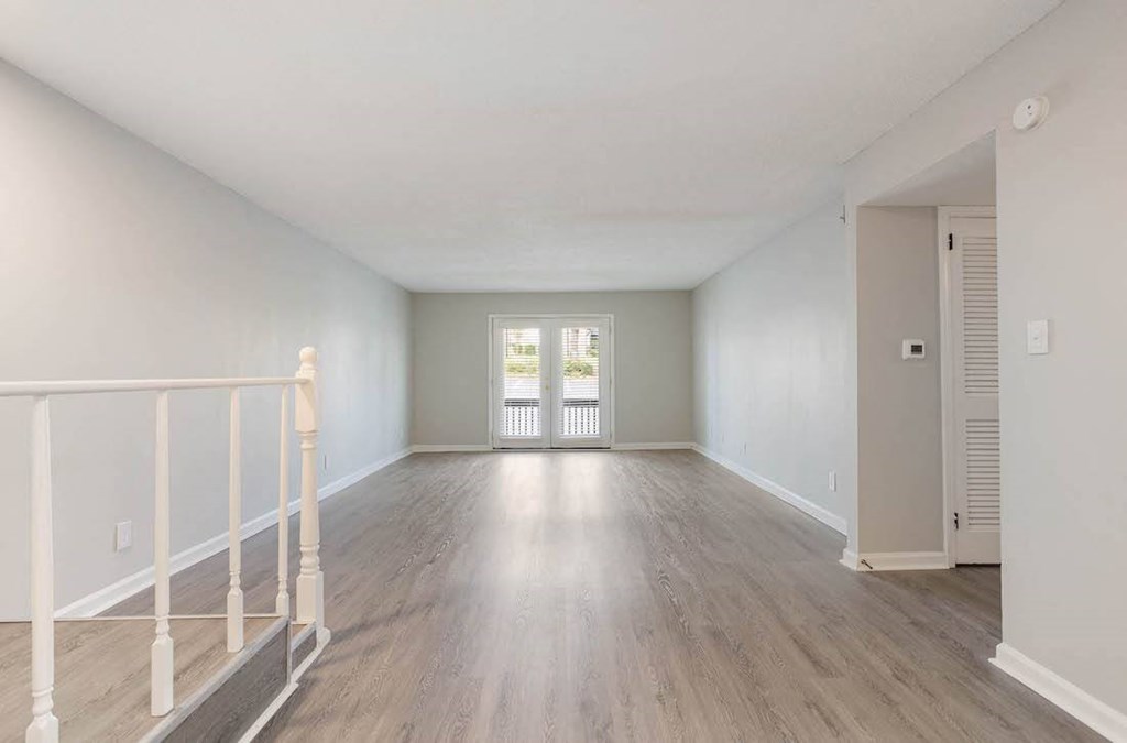 an empty living room with a small staircase in the corner