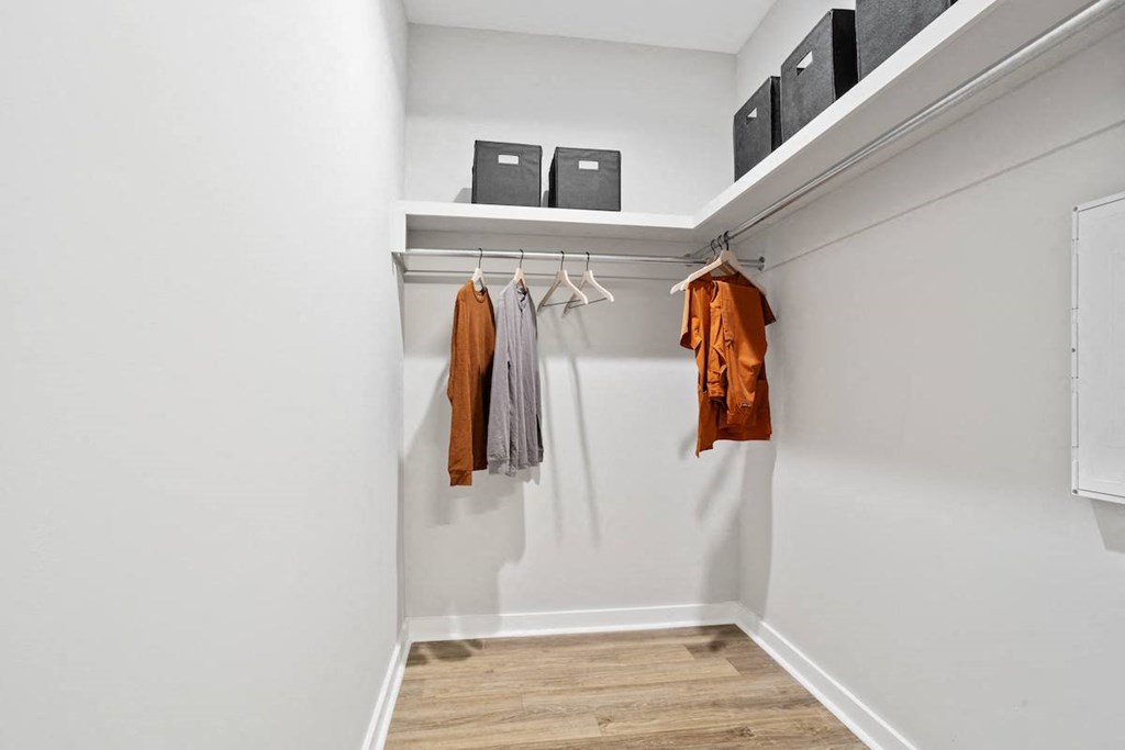 a large walk-in closet with hanging bars and built-in shelving in a home at Sanctuary at Indian Creek homes for rent