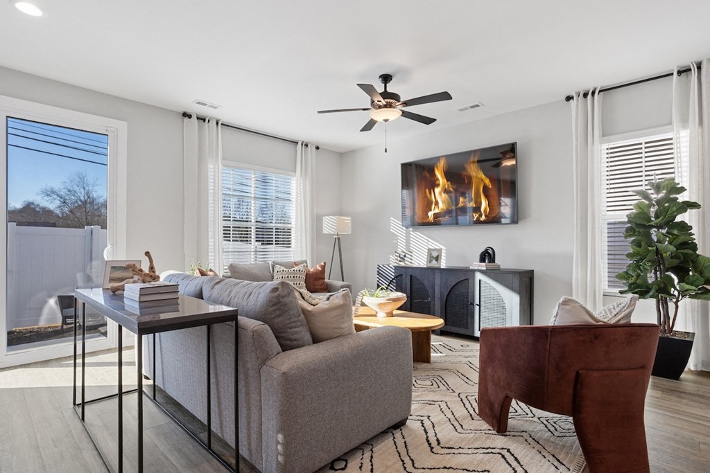 a spacious, furnished living room with large windows and glass doors to a private back yard in a home at Sanctuary at Indian Creek