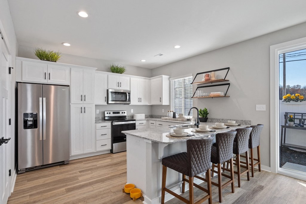 a kitchen with a large island and a stainless steel refrigerator at Sanctuary at Indian Creek rental homes near Redstone Arsenal