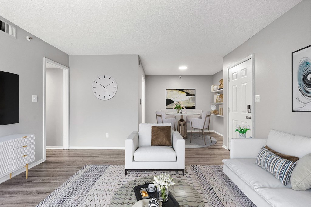a living room and dining room with a large clock on the wall