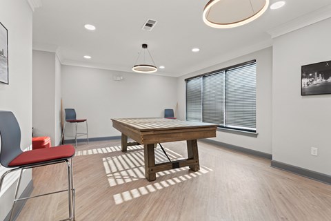 a spacious game room with a pool table and chairs