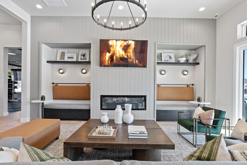 a cozy clubhouse with furnishings, decor, and a fireplace playing on the TV screen